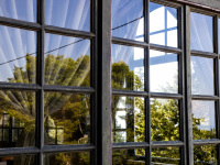 the landscape is reflecting in a wooden lattice window of the elafos hotel on rhodes
