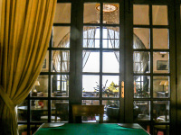 a green poker table in front of a dark wooden lattice door in the hotel elafos on Rhodes