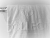 a white hotel towel where is lettering the name of the hotel of it, the nh collection köln mediapark in cologne