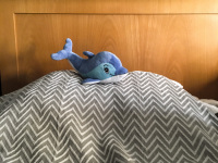 a little blue travel-dolphin lays on the pillow in the savoy hotel in piraeus