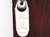 at a doorknop in the savoy hotel in piraeusa sign with lettering please do not disturb in english and in greek