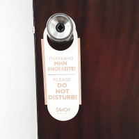 at a doorknop in the savoy hotel in piraeusa sign with lettering please do not disturb in english and in greek
