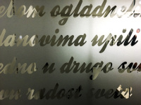 a frosted glass window pane with lettering in serbian in clear glass in the hotel crystal light in nis