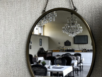 in an oval mirror you see the breakfast room with black chairs and big chandeliers in the hotel esprit in bratislava