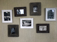on a beige wall hangs a little collection of pictures in wooden frames in the esprit hotel in bratislava
