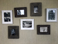 on a beige wall hangs a little collection of pictures in wooden frames in the esprit hotel in bratislava