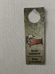 a a grey wall hangs a olive green sign with lettering please do not disturb in english and in slovak in the esprit hotel in bratislava