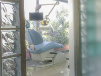 through a door next to big glass blocks you look on a light blue dentist chair in a dental practice in rhodes city