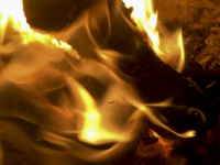 behind a kiln glass is burning a yellow fire