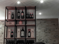 someone is sittingin front of a shelf with bottles of redwine in the saro tapas bar & lounge in osnabrück