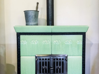 on an old light green oven is standing a metall bucket