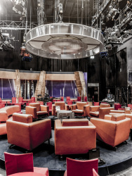 red and light brown armchairs are standing in a circle in a tv-studio in cologne mühlheim