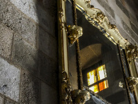 an old golden mirror with ornamentation at a stone wall of the grandmaster palace in rhodes city