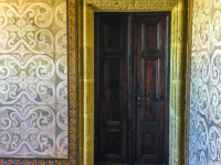 an old brown wooden door in a room full of ornaments at the wall in the grandmaster palace on rhodes