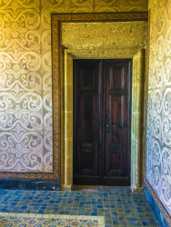 an old brown wooden door in a room full of ornaments at the wall in the grandmaster palace on rhodes