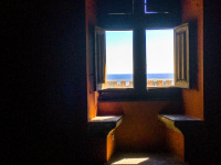 stony benches and an open wooden window with a view to the sea in the grandmaster palace on rhodes