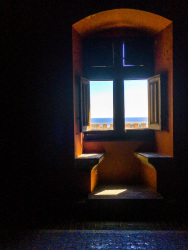 stony benches and an open wooden window with a view to the sea in the grandmaster palace on rhodes