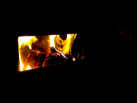the open hatch of an oven with a cozy burning fire in it