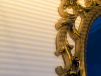 the evening sun is shining on an golden ornamental mirror