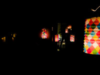 dark self-portrait with colorful lanterns