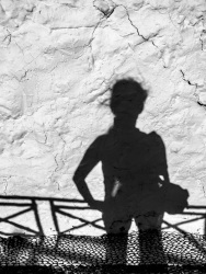 shadow self-portrait with bag at a white wall, black-and-white