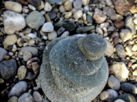 on a stone beach there is builded a little tower of grey stones