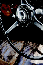 the black steering wheel and the brown leather seat of a rolls royce 25/30
