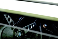 view through the open window of an oldtimer bmw e28 to the steering wheel and the gear stick