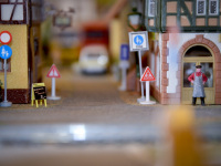 view in a street with stores and road signs on a model railway