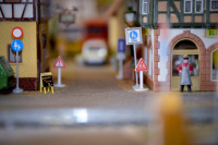 view in a street with stores and road signs on a model railway
