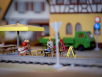 people in a beer garden in a little town on a model railway