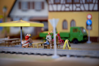 people in a beer garden in a little town on a model railway