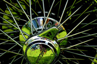 green grass ist reflecting in the chrome spoke rim of a jaguar
