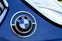 the emblem of bmw with chrome on a light blue oldtimer bmw