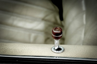 an oldtimer has beige leather seats and a lock knob with a brown wooden head