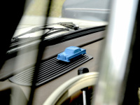 on the dashboard of a mercedes benz oldtimer the owner presents his car in a light blue small model