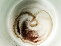 a coffee grounds in a mint colored cup looks like a heart