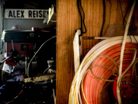 you see in a workshop an orange trimmer wire, other stuff and a sign with lettering alex reisen
