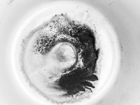 an artful coffee grounds in a white cup, black-and-white