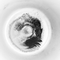an artful coffee grounds in a white cup, black-and-white