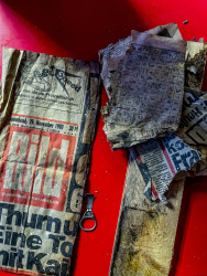 a pull tab, a small wooden board, an old peace of the newspaper Bild from 1980 and an old crossword puzzle