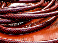 a wet red garden hose on a wet red wooden table
