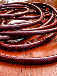 a wet red garden hose on a wet red wooden table