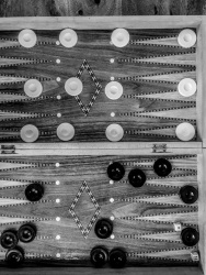 a backgammon board with white and black game pieces, black-and-white