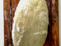 a foamy soap in beige on a brown bowl made of olive wood