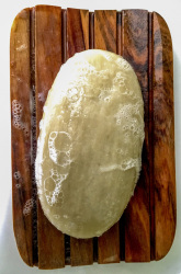 a foamy soap in beige on a brown bowl made of olive wood