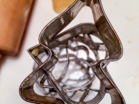 stainless steel cookie cutters for christmas, cookie dugh and a wooden rolling pin