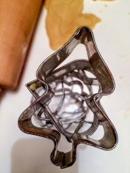 stainless steel cookie cutters for christmas, cookie dugh and a wooden rolling pin