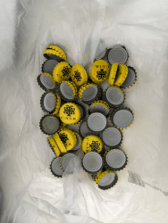 a little collection of yellow bottle caps of the cair wine retsina