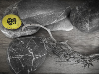 grey stones and grey driftwood in combination with a yellow bottle cap of the cair wine retsina